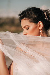 Close-up portrait of a brunette model girl in the role of a bride. Beautiful face, portrait at...
