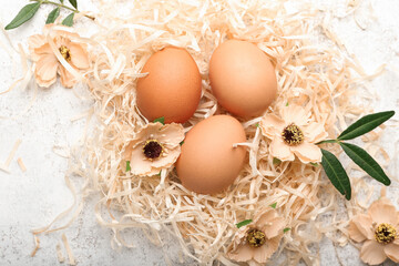 Easter eggs and flowers on light background