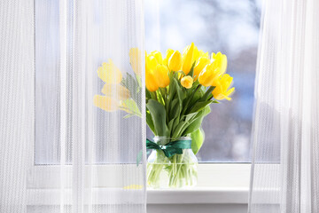 Bouquet of beautiful yellow tulip flowers on windowsill