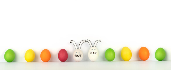 Happy Easter. Creative banner from multi-colored eggs in row and two funny rabbits. White background