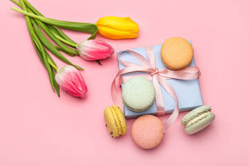 Composition with gift for International Women's Day celebration, sweet macaroons and tulip flowers on pink background