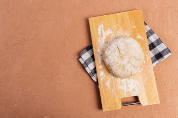 Preparation of the dough with flour on a brown background. Free space for text.