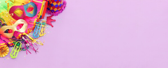 Purim celebration concept (jewish carnival holiday) over purple wooden background © tomertu