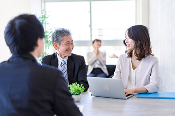 楽しい雰囲気でミーティングをするビジネスパーソン