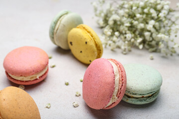 Sweet macaroons and gypsophila flowers on light background, closeup