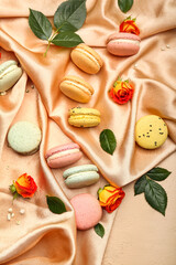 Composition with sweet macaroons, rose flowers and leaves on fabric background. International Women's Day celebration