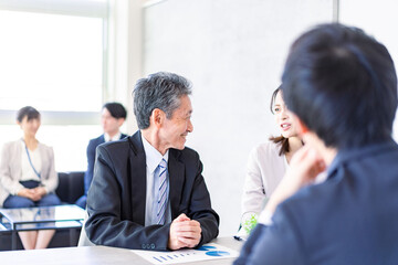 楽しい雰囲気でミーティングをするビジネスパーソン