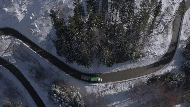 Pickup Truck Pulling A Trailer Driving A Hairpin Bend On The Mountain Winter Road, Aerial Tracking Shot.