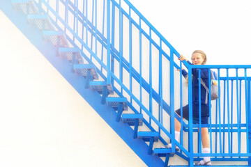 Schoolgirl climbs the stairs. stage, career ladder. girl in a uniform with a backpack. Girl go up, a step up the stairs