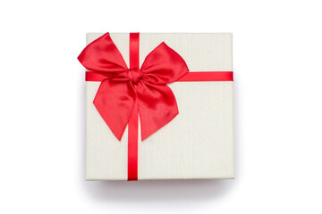 White gift box with a red ribbon and a bow on a white background. Gift for birthday or traditional holiday. Gift box close up