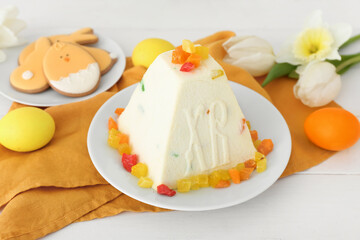 Delicious curd Easter cake with candied fruits and eggs on light wooden background