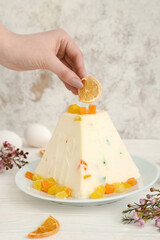 Woman decorating curd Easter cake on table, closeup