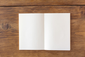 茶色の木製のテーブルの上の空白の見開きのノート