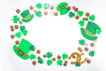 Obraz na płótnie Canvas St Patrick flatlay background with shamrock clover leaves, leprechaun hat decor, golden coins and chocolates in form of symbol of st. patrick day