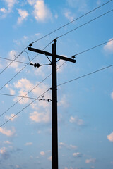 Close up shot of electricity transmission pole under the blue sky in the evening