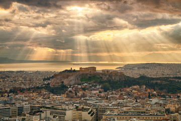 Greece. Athens. The Parthenon on Mount Acropolis against a cloudy sky, in the mystical rays of the sun - 488801309