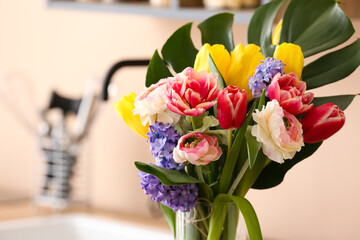 Beautiful bouquet of flowers in kitchen, closeup