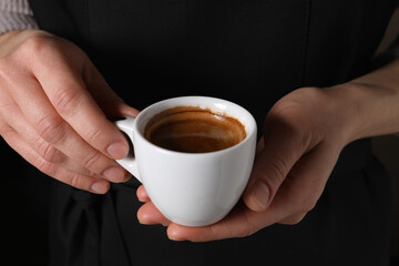 Woman holding cup of fresh aromatic espresso, closeup