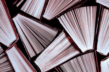 Books. Many old books in a book shop or library. Lots of colourful thick open books stand on a dark background