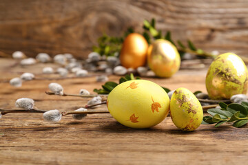 Painted Easter eggs and pussy willow branches on wooden background