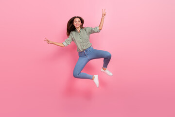 Photo of charming funny woman wear striped shirt showing v-sign jumping high isolated pink color background