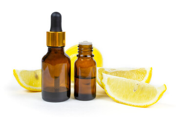 Aromatic lemon essential oil in two brown glass bottles with pipette and dispenser on a white insulated background. Aromatherapy, spa, skin care.