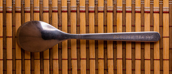 Teaspoon made of stainless steel on a bamboo mat