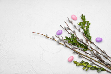 Painted Easter eggs and branches on light background