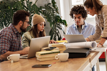 Group of casually dressed young businesspeople discussing ideas at the office about a new startup project.Female coworker talking about business strategy.	
