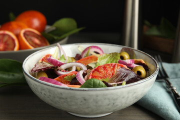 Bowl of delicious sicilian orange salad on wooden table, closeup