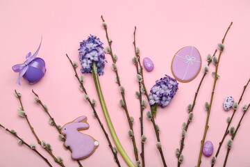 Willow branches, Easter cookies, flowers and painted eggs on pink background