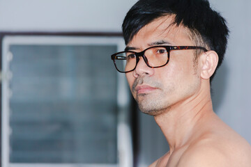 portrait asian man with glasses standing in the house during the day at home