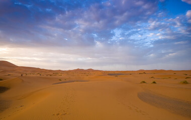 Picturesque cloudscape above the dune Erg Chebbi in the desert of Morocco on an early summer day