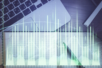 Stock market graph and top view computer on the table background. Multi exposure. Concept of financial education.