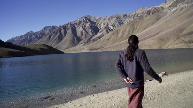 Young man enjoying the nature and feeling the beauty of chandratal lake(moon lake), Himachal Pradesh. A man alone into himalayas. Travel Lifestyle.