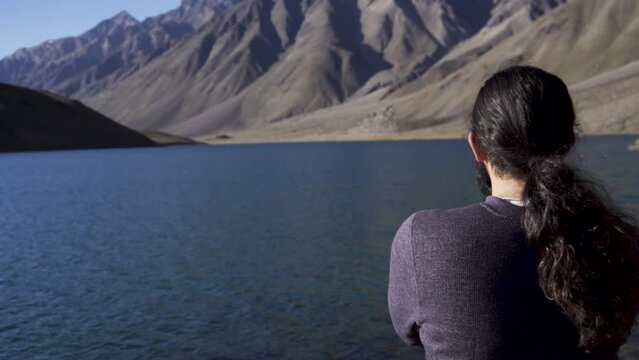 Young man enjoying the nature and feeling the beauty of chandratal lake(moon lake), Himachal Pradesh. A man alone into himalayas. Travel Lifestyle.