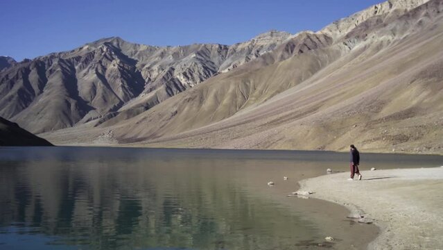 Young man enjoying the nature and feeling the beauty of chandratal lake(moon lake), Himachal Pradesh. A man alone into himalayas. Travel Lifestyle.