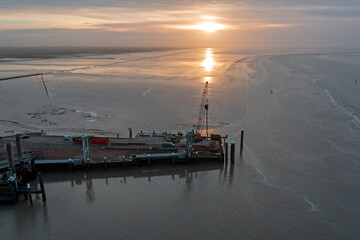 Aerial from the harbor in Holwerd with work in progress in the Netherlands at sunset