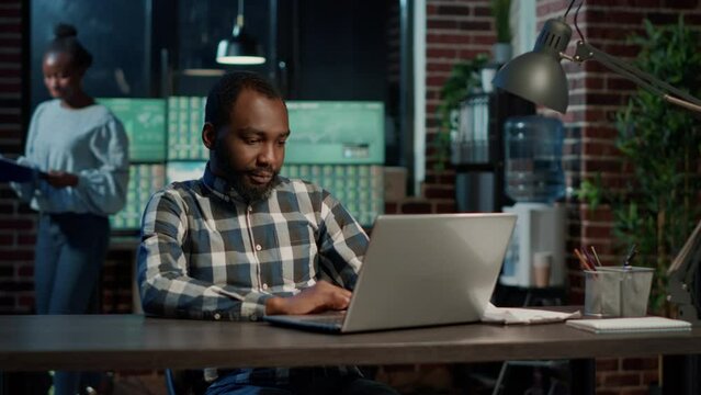 Financial analyst working with stock market sales on laptop, monitoring forex investment strategy for financial growth. Using profit exchange and hedge fund to buy and sell money. Tripod shot.
