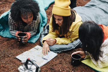 Friends checking a map while camping