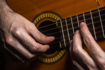 Hands playing acoustic guitar. Playing the guitar close up. Music hobby