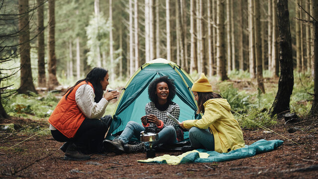 Women sitting at their campsite in the woods - Powered by Adobe