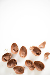 Happy Easter. Open broken destroyed crumbled chocolate eggs on a white background. Holiday. Space for text