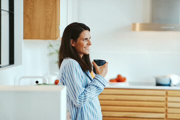 Woman in pajamas drinking coffee