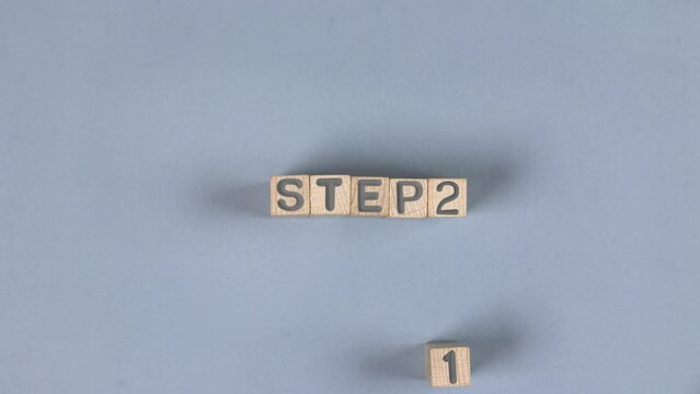 Wooden blocks with Step 1 sign going to Step 2. Concept of Change, Choice and Strategy. High quality 4k video