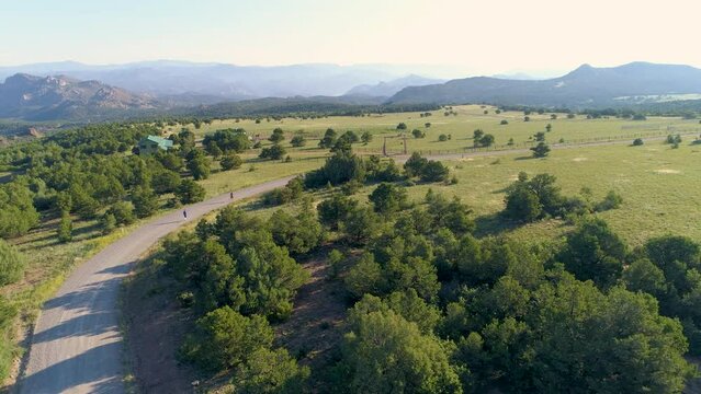 Runners on a road by a mountain ranch in the morning
