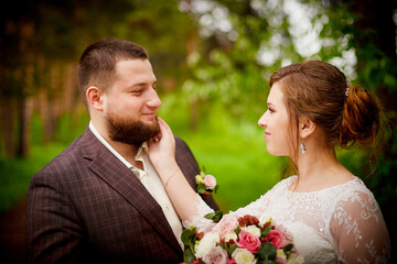 Wedding concept. Bride and groom in green park in a summer day