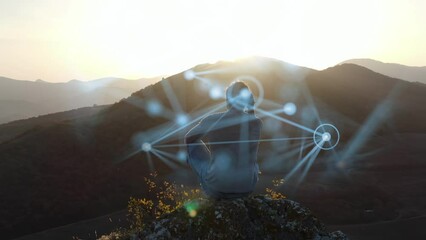 The concept of psychological training. A man sits on top of a cliff at sunset and tries to organize his thoughts. The process of concentration is visualized by means of computer graphics