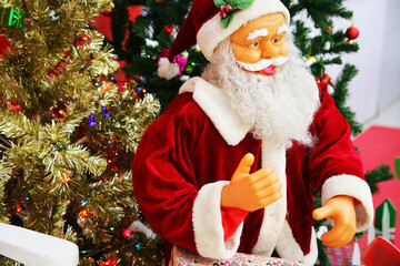 Smiling senior santa claus in eyeglasses with gift and presents looking at camera