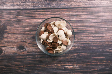 Fototapeta na wymiar Top view of chocolate corn flakes in a bowl on wooden table